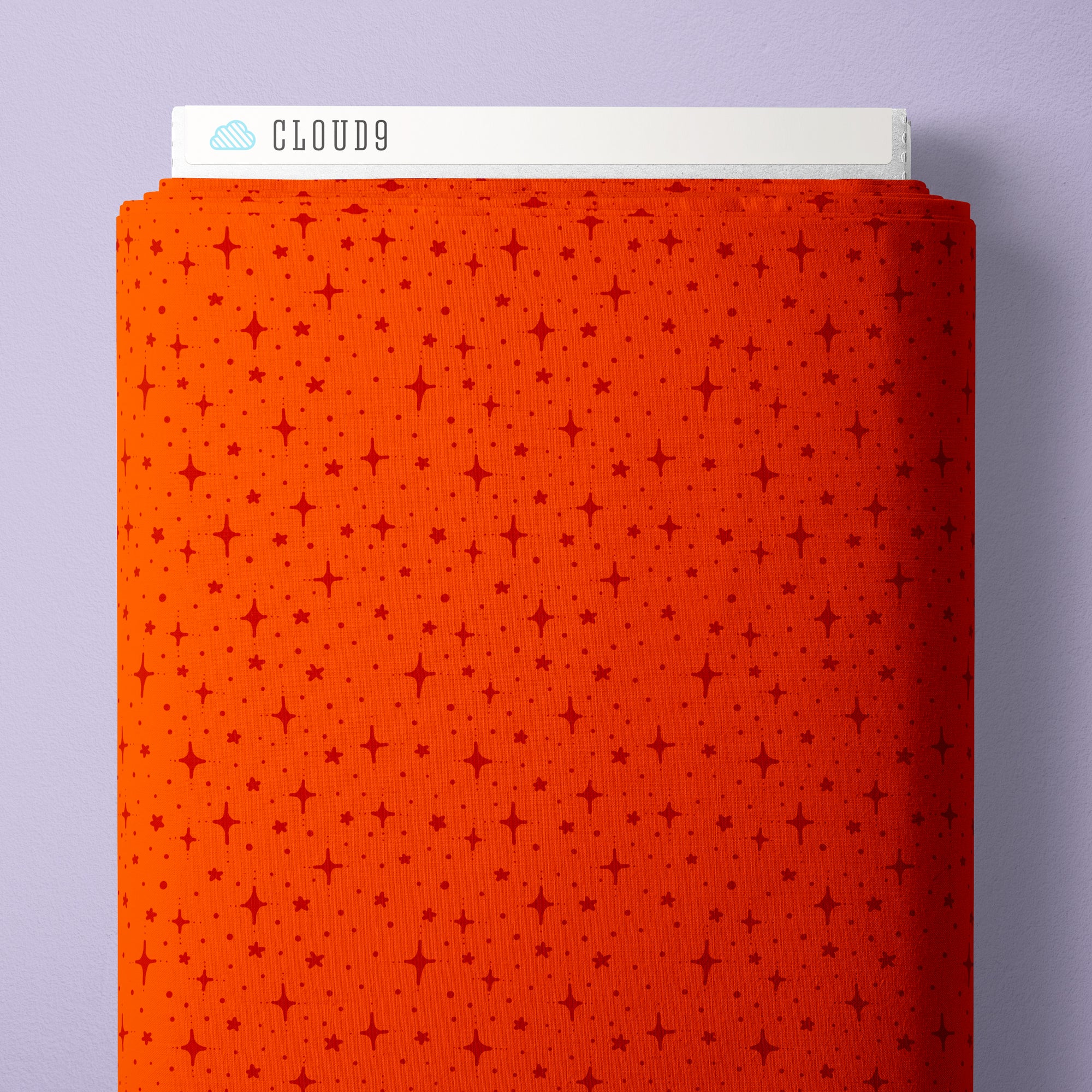 A roll of bright orange fabric with a repeating pattern of small red stars and dots, shown with a white label at the top reading CLOUD9 against a light lavender background.