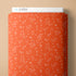 Fabric with white symbols on an orange cover against a beige background
