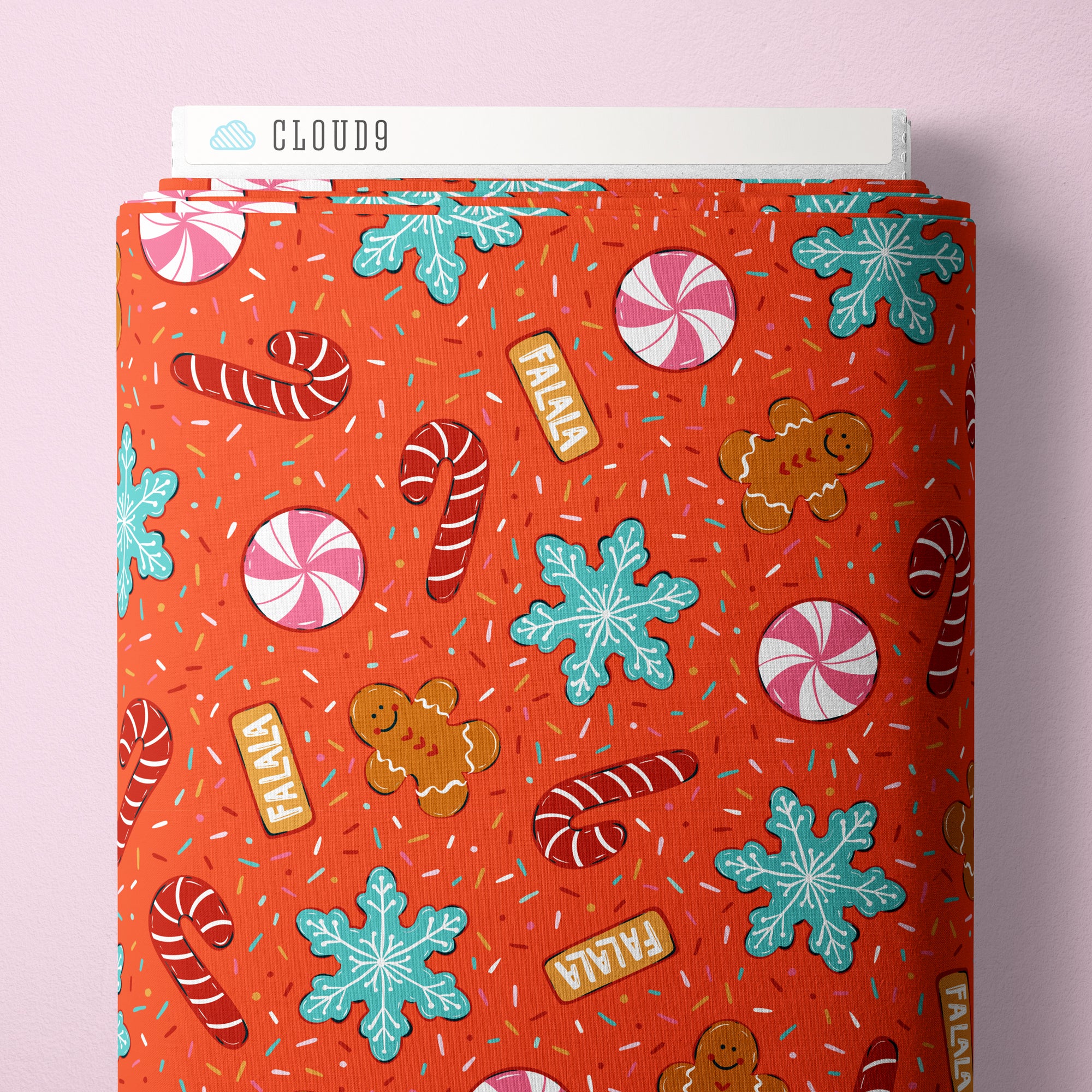 Red fabric bolt with Christmas-themed pattern on a pink background