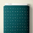 A roll of teal fabric with a small white geometric dot pattern, branded with the CLOUD9 logo on the top edge, set against a plain beige background.