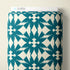 A roll of wallpaper with a repeating teal bird pattern on an off-white background, with a white header card labeled CLOUD9 visible at the top, set against a neutral beige wall.