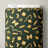 A roll of dark green fabric with a repeating pattern of gold pasta shapes, shown partially unrolled with a white Cloud9 box visible at the top against a light gray background.