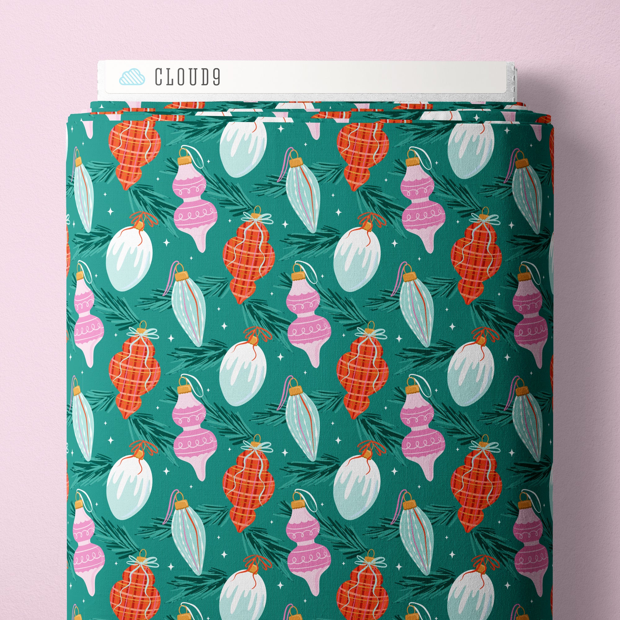 Fabric bolt with Christmas ornament pattern on a pink background
