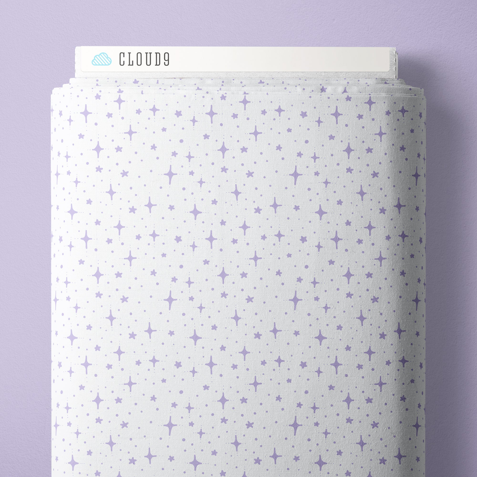 A roll of white fabric with a repeating pattern of small purple stars and sparkles, shown against a light purple background. The brand name 'CLOUD9' is visible on the top edge of the fabric roll.