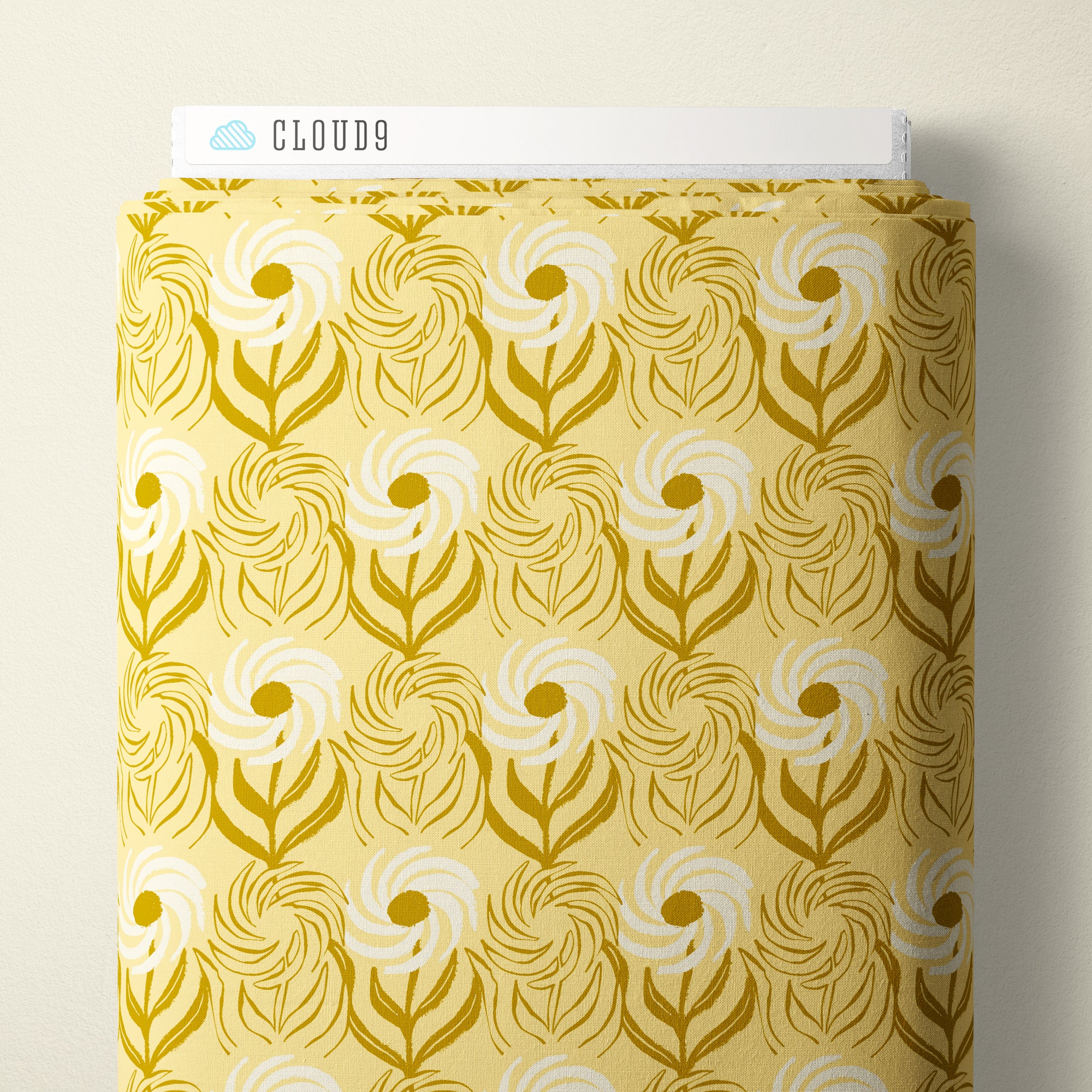 A roll of patterned fabric with a retro floral swirl design in mustard yellow and white, labeled with a white header card that reads CLOUD9.