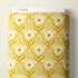 A roll of patterned fabric with a retro floral swirl design in mustard yellow and white, labeled with a white header card that reads CLOUD9.