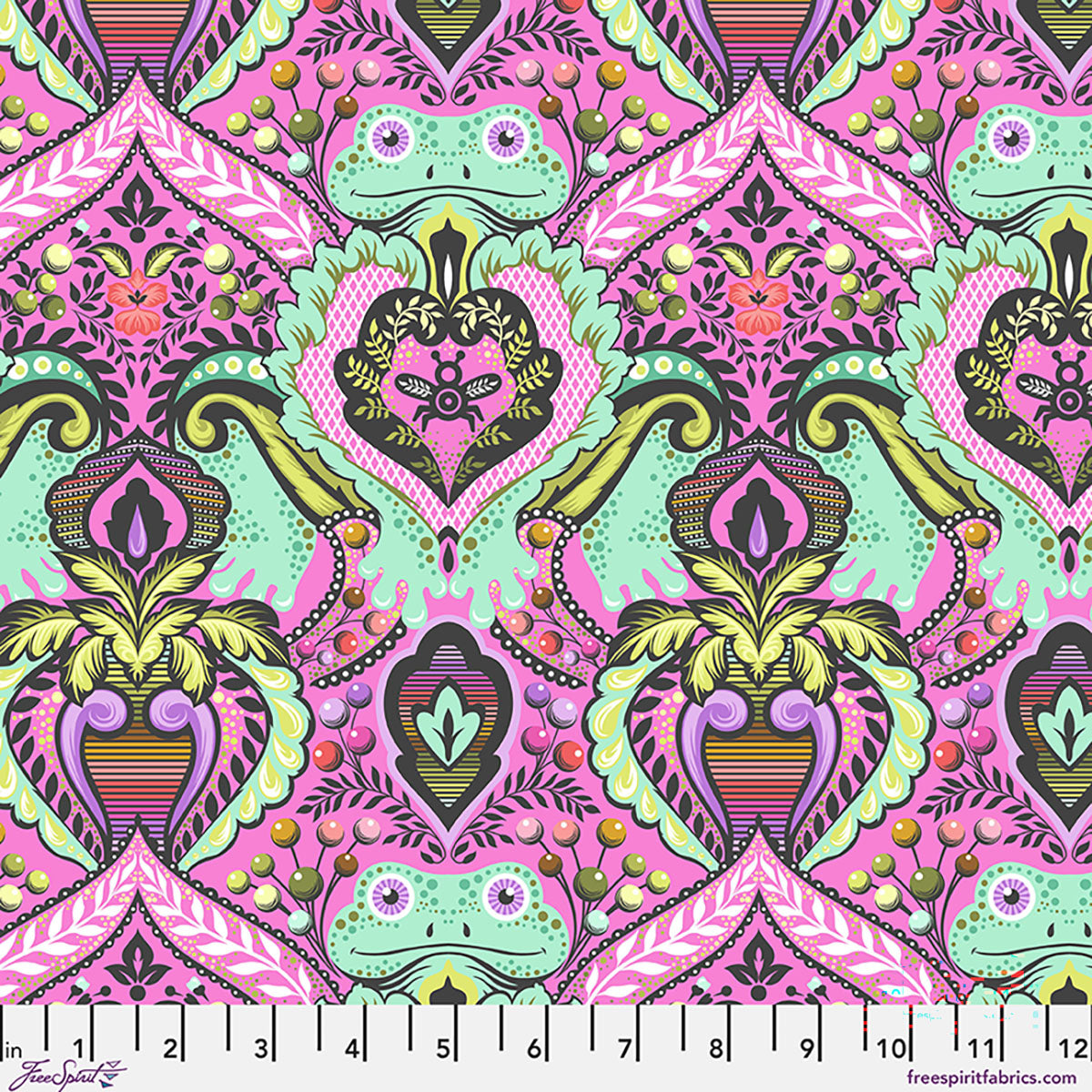 Colorful patterned fabric with geometric shapes and vibrant colors, displayed on a ruler for scale.