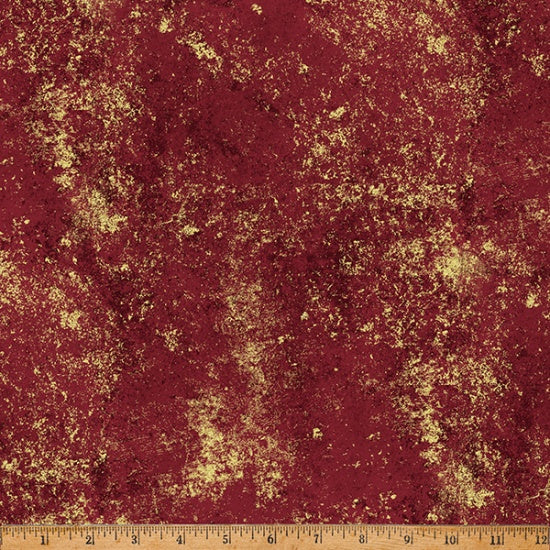 Textured red fabric with gold speckles and a ruler at the bottom for scale.