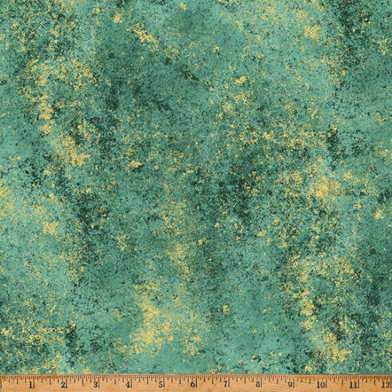 Textured green fabric with gold specks and a ruler at the bottom for scale.