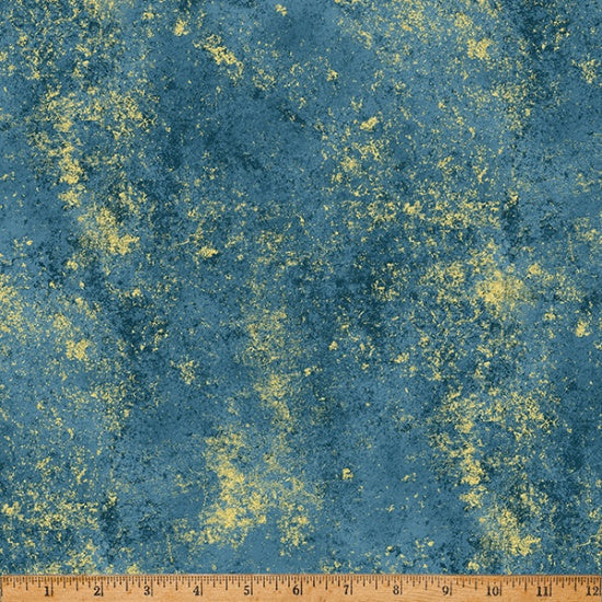 Textured blue fabric with yellow specks and a ruler at the bottom for scale.