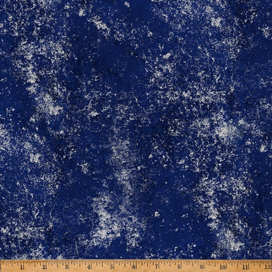 Blue fabric with white speckles and a wooden ruler at the bottom