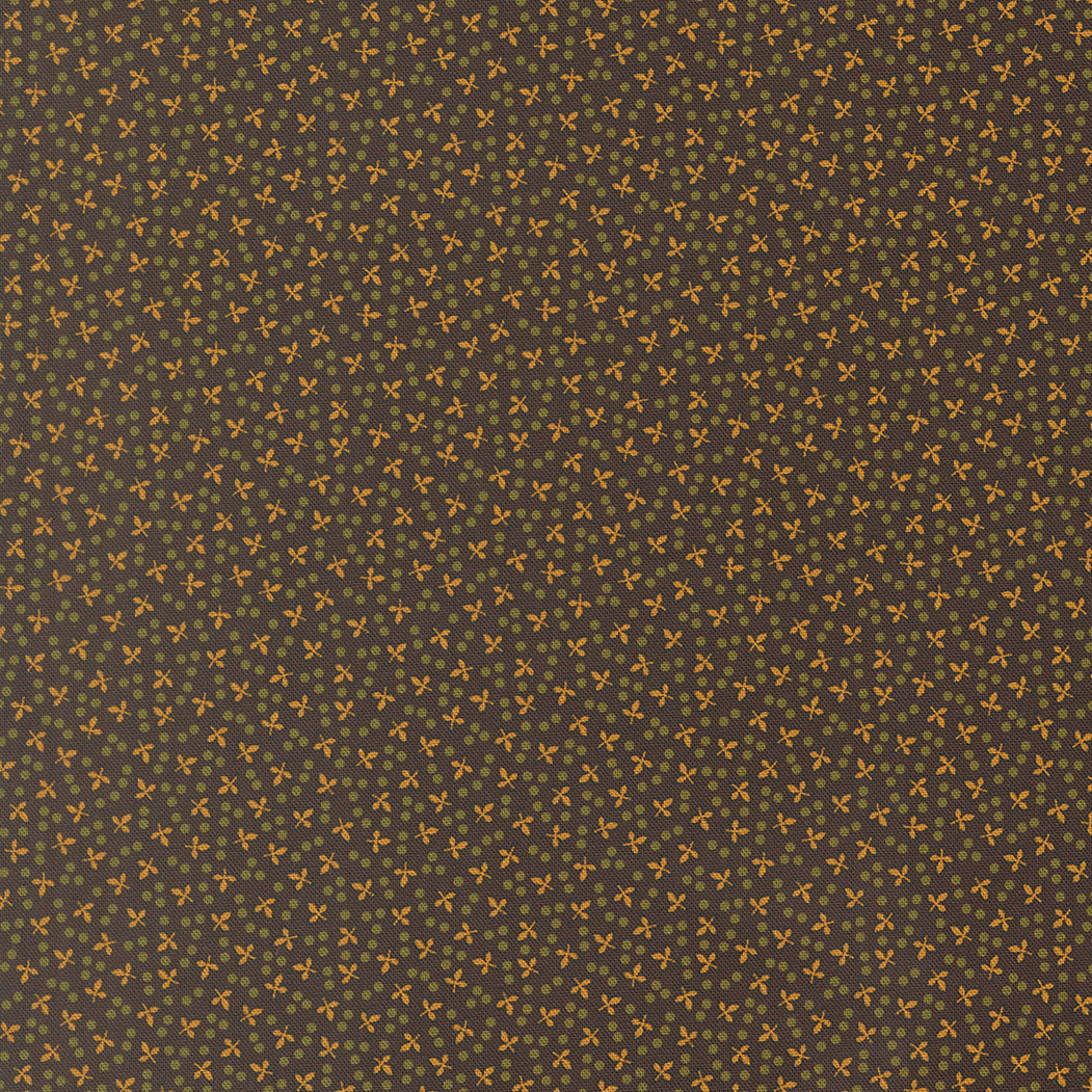 A close-up of a repeating fabric pattern with a dark charcoal gray background and small warm yellow-orange floral motifs scattered across it.