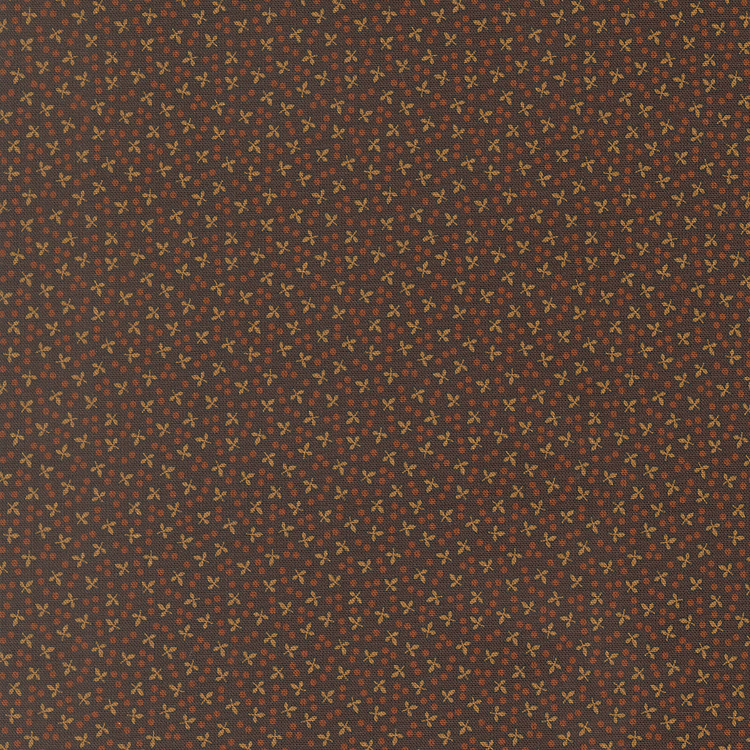 A close-up of a repeating fabric or material pattern with a dark brown background and small warm beige cross-like motifs repeated across the surface.
