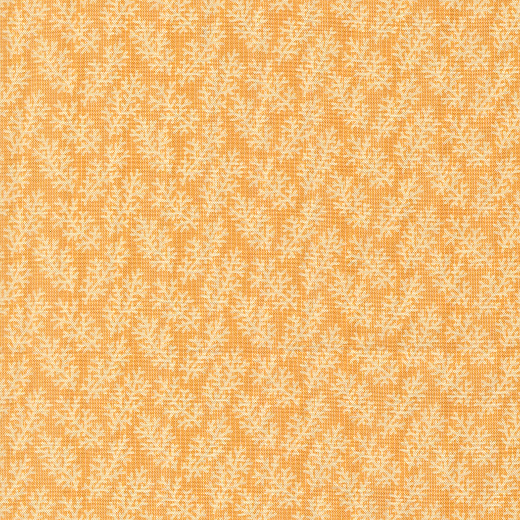 A close-up of a fabric or wallpaper pattern featuring a repeating cream-colored botanical leaf motif on a warm mustard yellow background.