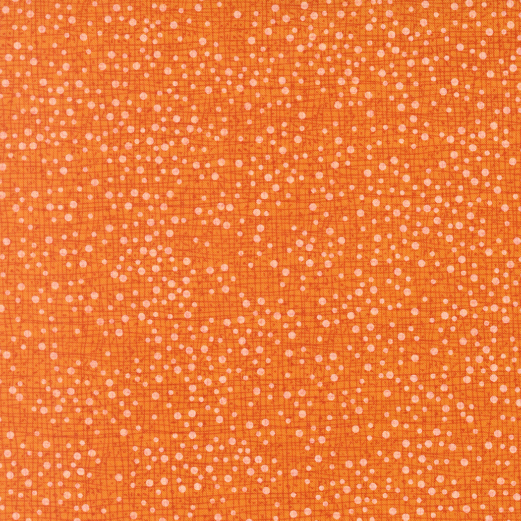 Textured orange fabric pattern with small white dots