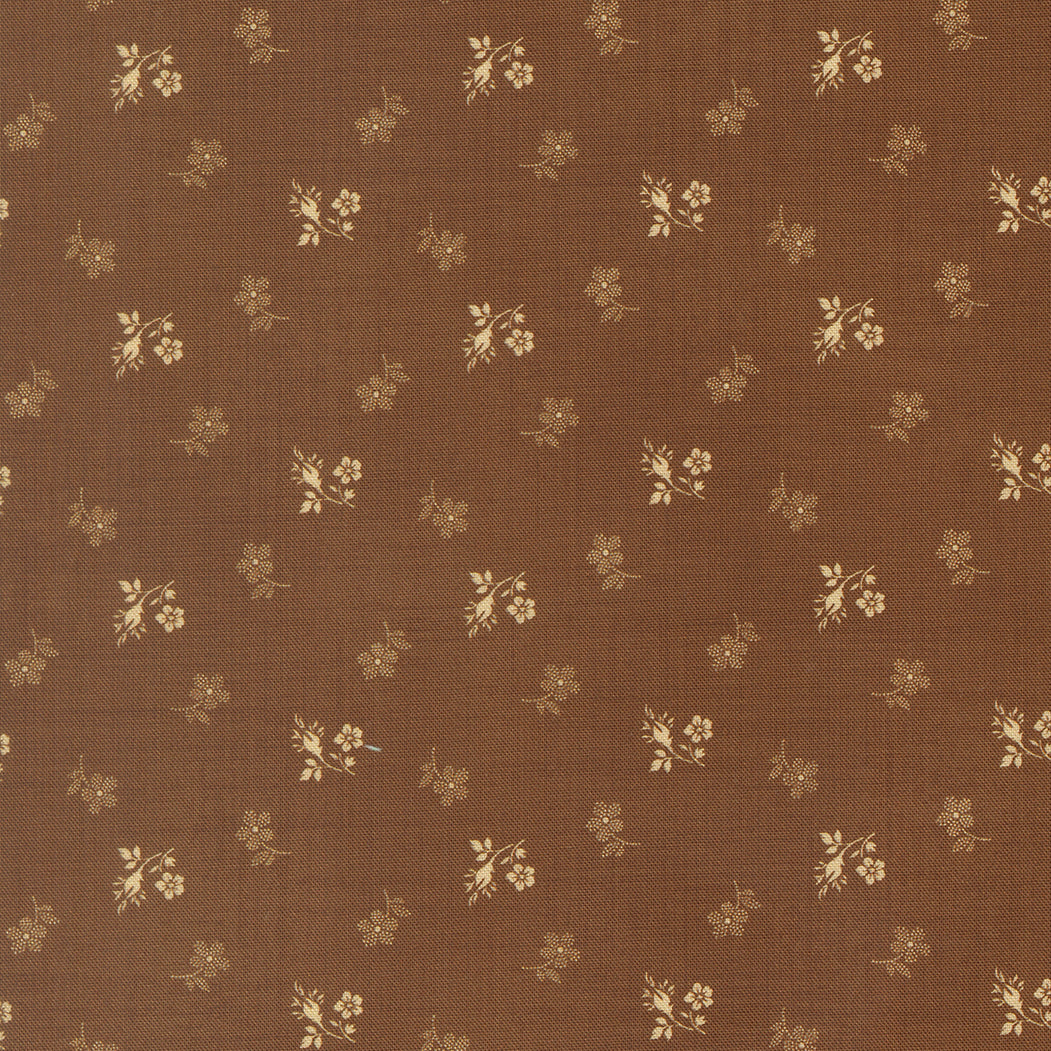 Brown fabric with a repeating pattern of small beige floral and leafy motifs.