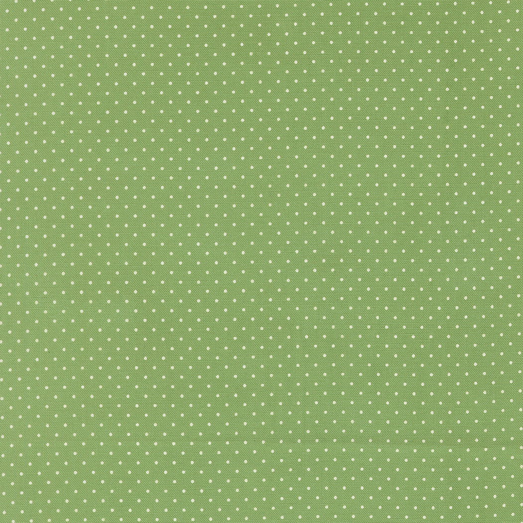 Green fabric with small white polka dots