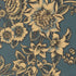 A close-up of a floral patterned fabric or wallpaper featuring large cream-colored flowers and leaves on a muted blue-gray background.