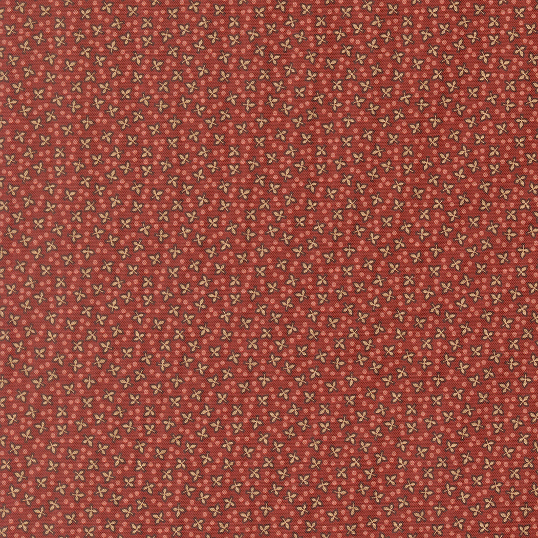 A close-up of a fabric pattern featuring a repeating design of small cream-colored bows on a warm rust-red background.