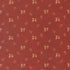 A close-up of a rust red fabric with a repeating pattern of small beige and light brown floral sprigs.