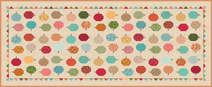 A table runner design featuring rows of colorful patterned pumpkin motifs on a warm beige background, framed by a decorative border of small triangles and geometric shapes.