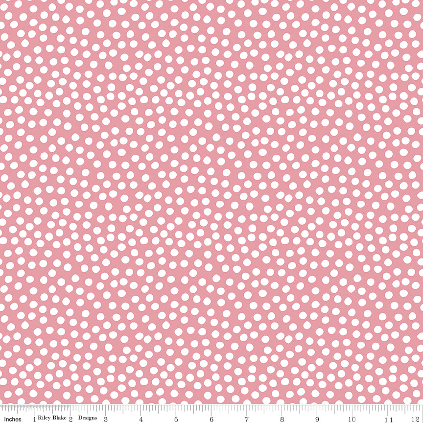 Pink fabric with white polka dots and a ruler at the bottom