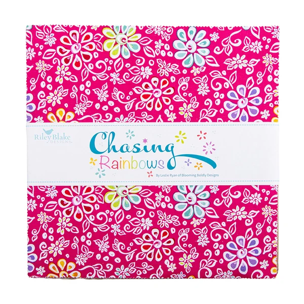 A folded fabric bundle from Riley Blake Designs featuring a bright pink background with a colorful floral and swirl pattern, wrapped in a white paper band labeled 'Chasing Rainbows'.
