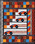 A colorful patchwork quilt design featuring four stylized red race cars with black wheels and blue centers, set against white patterned racing stripes, bordered by checkered and patterned blocks in orange, blue, black, and red.