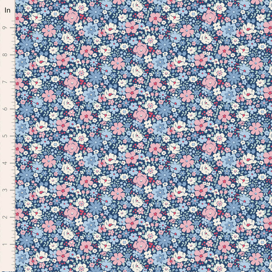 A close-up of a floral fabric pattern with small pink, light blue, white, and dark blue flowers on a navy background, shown next to a white ruler marked in inches for scale.
