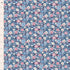 A close-up of a floral fabric pattern with small pink, light blue, white, and dark blue flowers on a navy background, shown next to a white ruler marked in inches for scale.