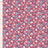 A close-up of a floral fabric pattern with small pink, blue, white, and yellow flowers on a dark red background, shown with a measurement ruler along the left edge.