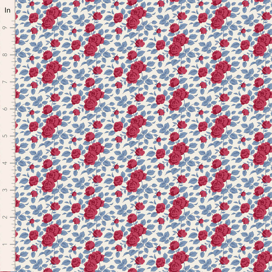 A close-up of a fabric pattern featuring red roses and blue leaves on a white background, with a measuring ruler visible along the left edge.