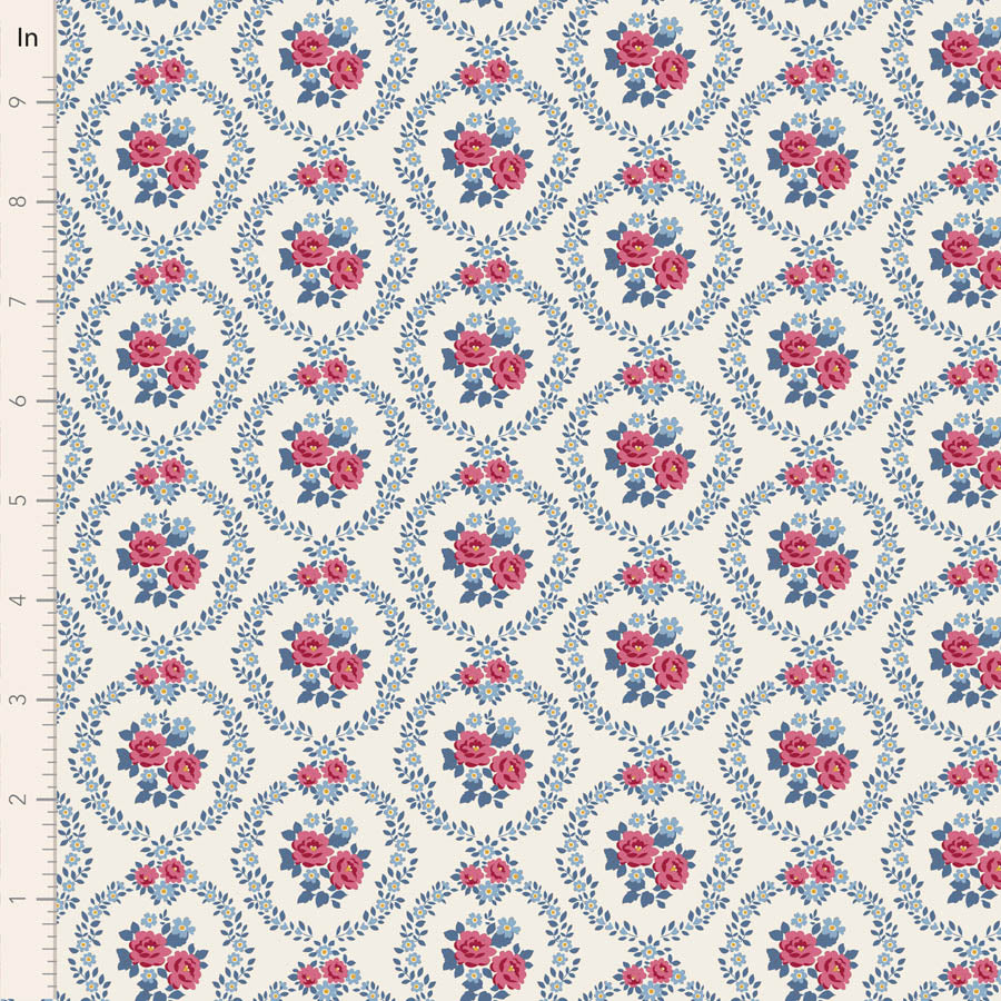 A close-up of a repeating floral fabric pattern with pink roses and blue leaves arranged in a diamond lattice on a warm off-white background. A ruler marked in inches appears along the left edge for scale.