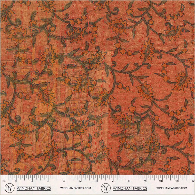 Floral patterned fabric with a ruler at the bottom for scale, on a red background.