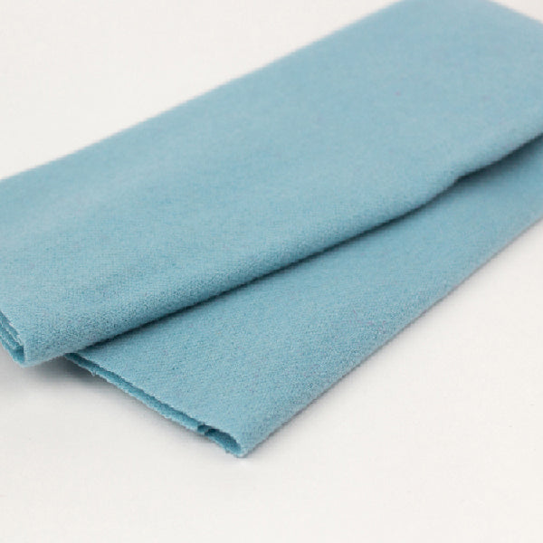 Folded light blue fabric on a white background