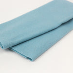 Folded light blue fabric on a white background