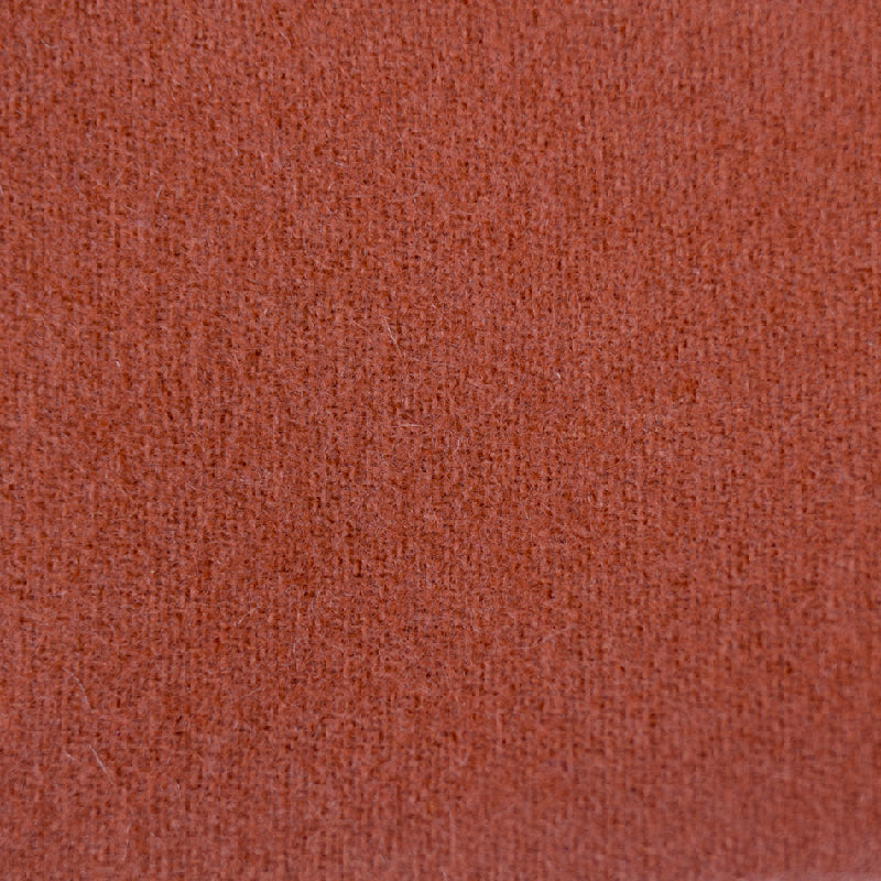 A close-up texture shot of a rust-colored woven fabric, showing the fine knit pattern and color details.