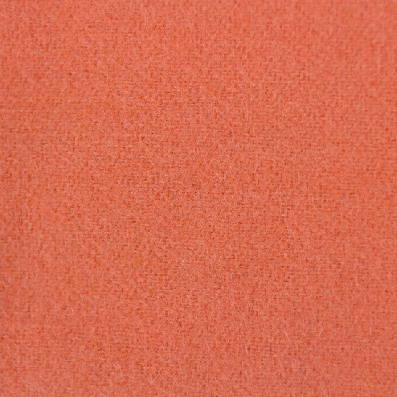 A close-up texture shot of a woven fabric in a warm coral-orange color.