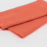 A folded piece of textured orange fabric, likely wool or felt, shown on a clean white background.