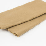 A folded piece of tan wool fabric, showing its soft, brushed texture, on a clean white background.