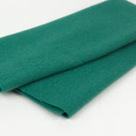 Roll of green wool fabric on a white background