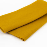 Mustard yellow fabric roll on a white background