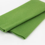 Folded green fabric on a white background