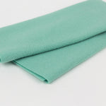 Folded mint green fabric on a white background