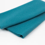 Teal fabric roll on a white background