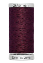 Spool of Gutermann thread in dark purple on a white background