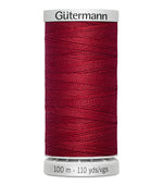 Spool of red Gutermann thread on a white background