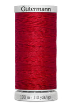 Red spool of Gütermann thread on a white background