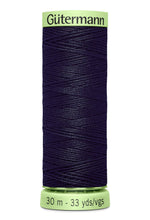 Spool of dark blue thread with green label on a white background