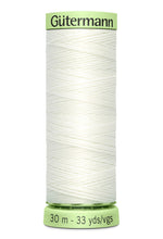 Spool of white thread with green label on a white background